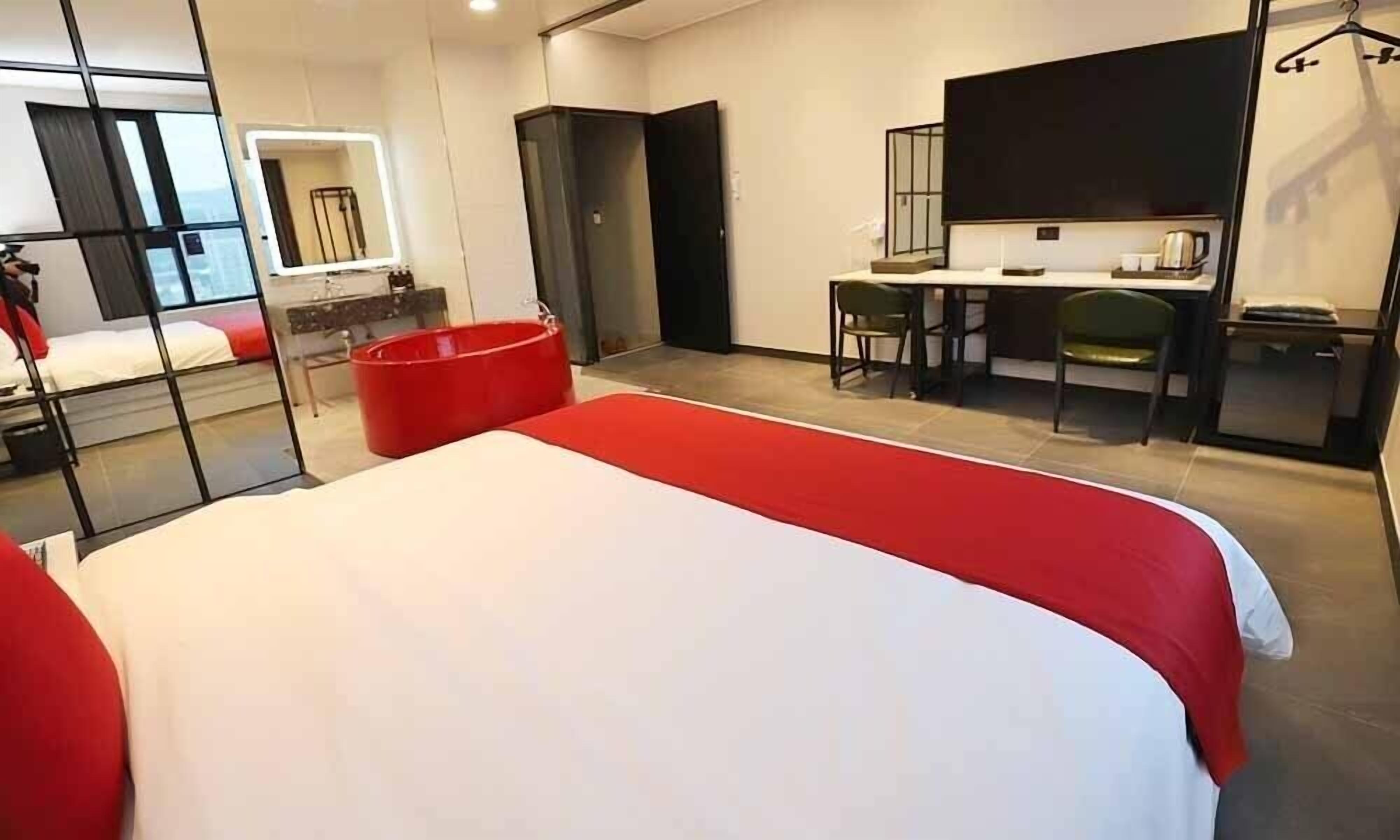 Una habitación de hotel moderna con una cama grande, un escritorio y una silla.