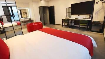 Una habitación de hotel moderna con una cama grande, un escritorio y una silla.