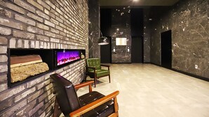 Un interior moderno con pared de ladrillo, chimenea y una silla verde.