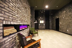 Un interior moderno con pared de ladrillo, chimenea y una silla verde.