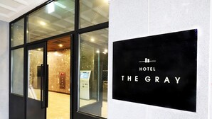 Entrada de un hotel con un cartel que dice "HOTEL THE GRAY".