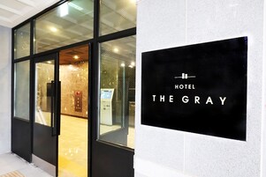 Entrada de un hotel con un cartel que dice "HOTEL THE GRAY".