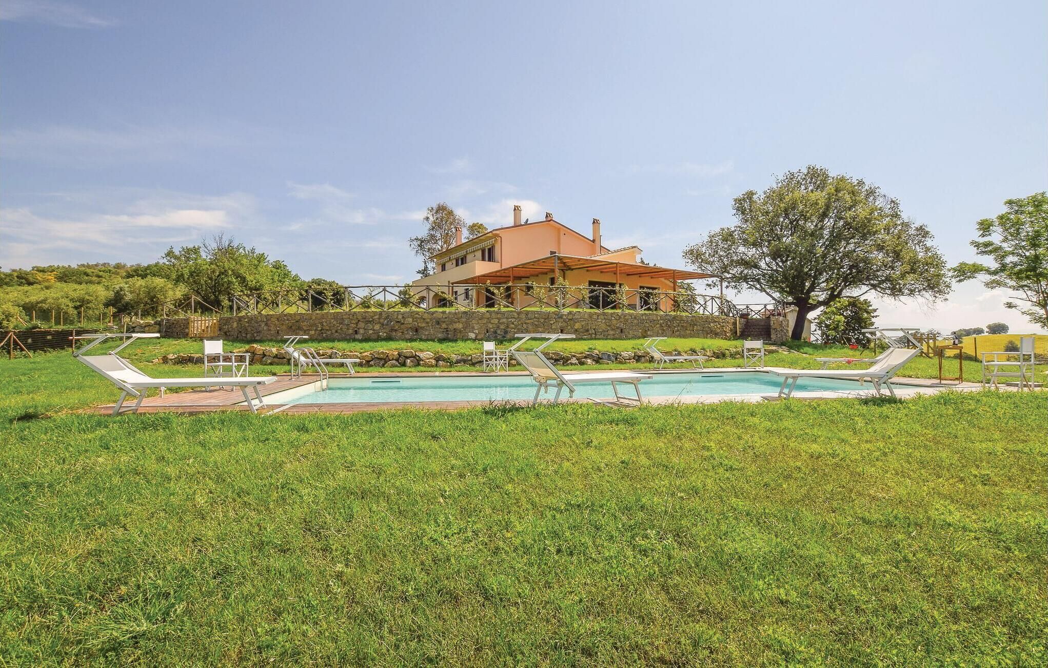 Una casa con piscina, rodeada de césped y árboles.