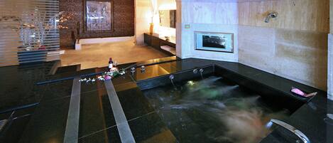 Een moderne spa met een bubbelbad, een receptiebalie en een tv aan de muur.