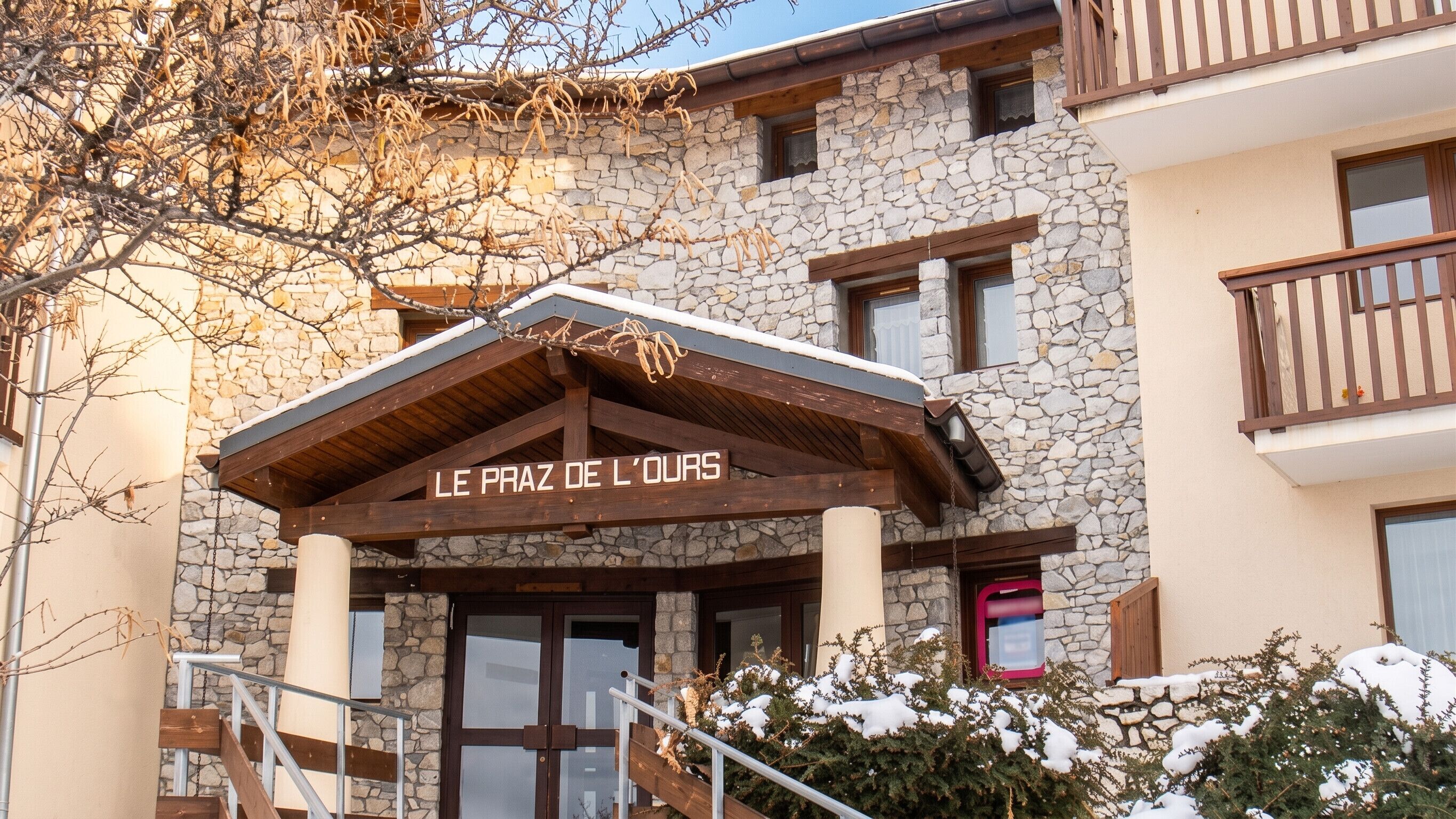 A stone building with a wooden entrance labeled 'LE PRAD DE L'OURS'.