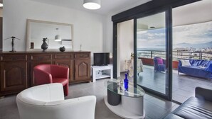 A modern living room with a large sliding glass door leading to a balcony with a city view. - Casa San Ghjisé (Bastia)