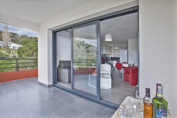 Un appartement moderne doté d’un balcon, d’un coin repas et d’une cuisine.