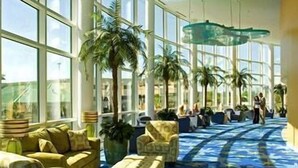 A spacious lobby with large windows, a patterned carpet, and a unique ceiling design. - Splash Luxury Oceanfront Condo with Master on Gulf! (Panama City Beach)