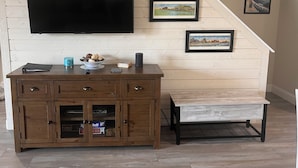 A wooden entertainment center with a flat-screen TV, a coffee maker, and a bowl of snacks. - Great Condo With Ocean Views!! (Brigantine)