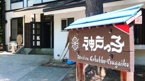 A wooden sign with Japanese characters and the name "Pension Kobekko Tsugane" in English. - Pension Kobekko (Otari)