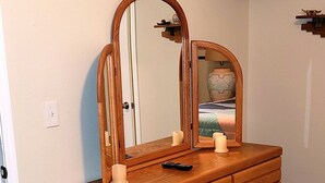 A wooden dresser with a mirror, candles, and a television mounted on the wall. - 5 STAR ESCAPE - Death Valley - Spring Mountain - Prairie Fire Nevada  (Pahrump)