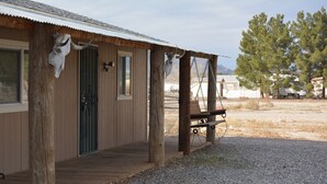 A rustic cabin with a wooden exterior, a porch, and a swing. - 5 STAR ESCAPE - Death Valley - Spring Mountain - Prairie Fire Nevada  (Pahrump)