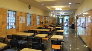 A spacious indoor dining area with multiple tables and chairs, wooden paneling on the walls, and ceiling lights. - Step Inn Shin-Osaka Higashiguchi (Osaka)