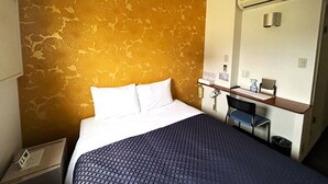 A hotel room with a bed, a desk with a chair, and a mirror. - Step Inn Shin-Osaka Higashiguchi (Osaka)