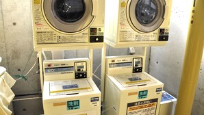 Two stacked washing machines with control panels and instruction manuals. - Step Inn Shin-Osaka Higashiguchi (Osaka)