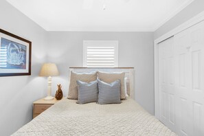 A bedroom with a bed, a nightstand, a lamp, a framed picture, and a window with blinds. - 👣Steps to Private Beach Access-Pool + Hot Tub-1BR Gulfview II 318🌊️ (Miramar Beach)