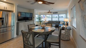 A modern kitchen with a dining area, a ceiling fan, and a view of the living room. - 120 steps to beach!  Safely on the beach side of the road! (Englewood)