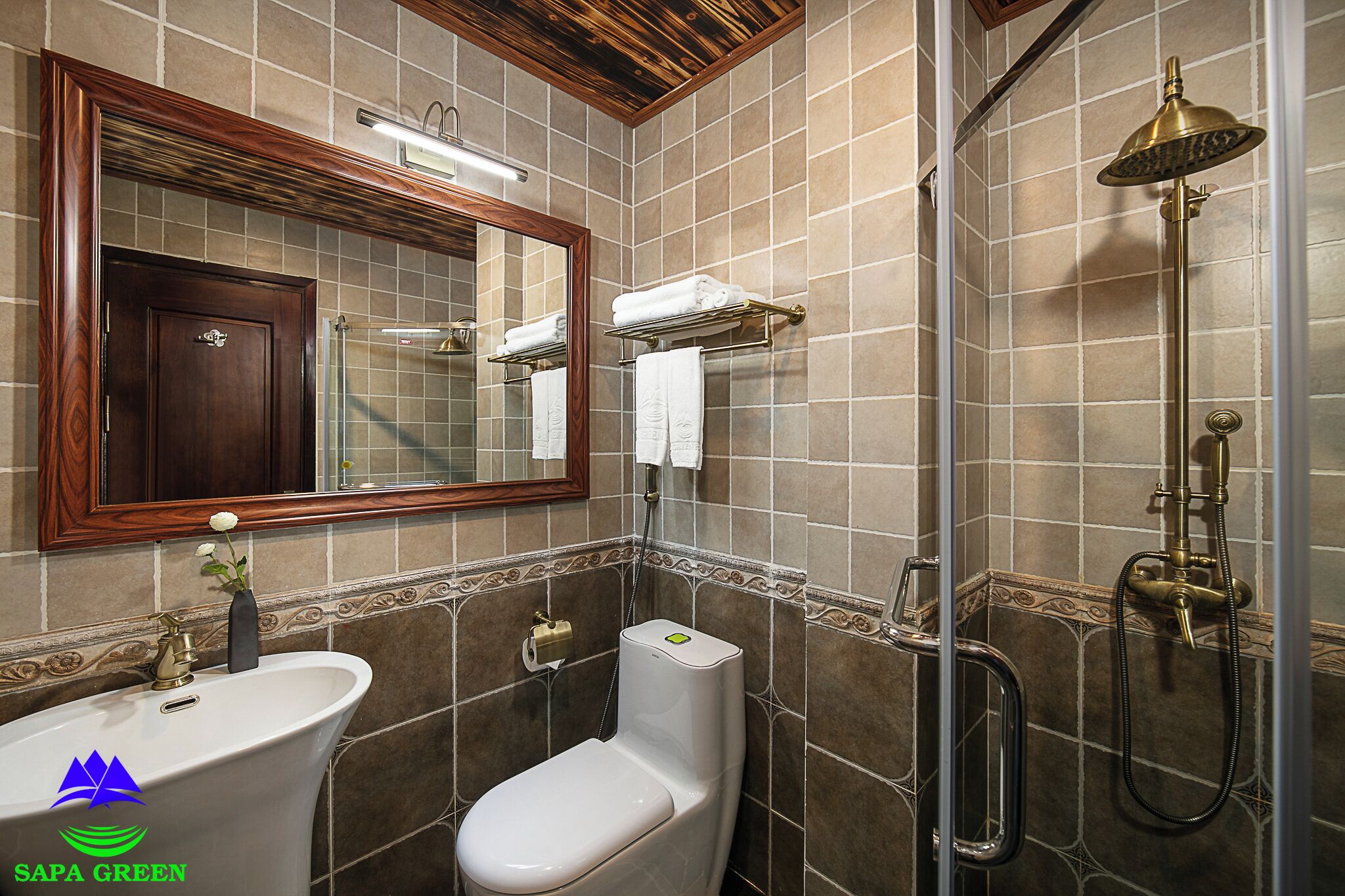 A bathroom with a sink, toilet, mirror, and shower.