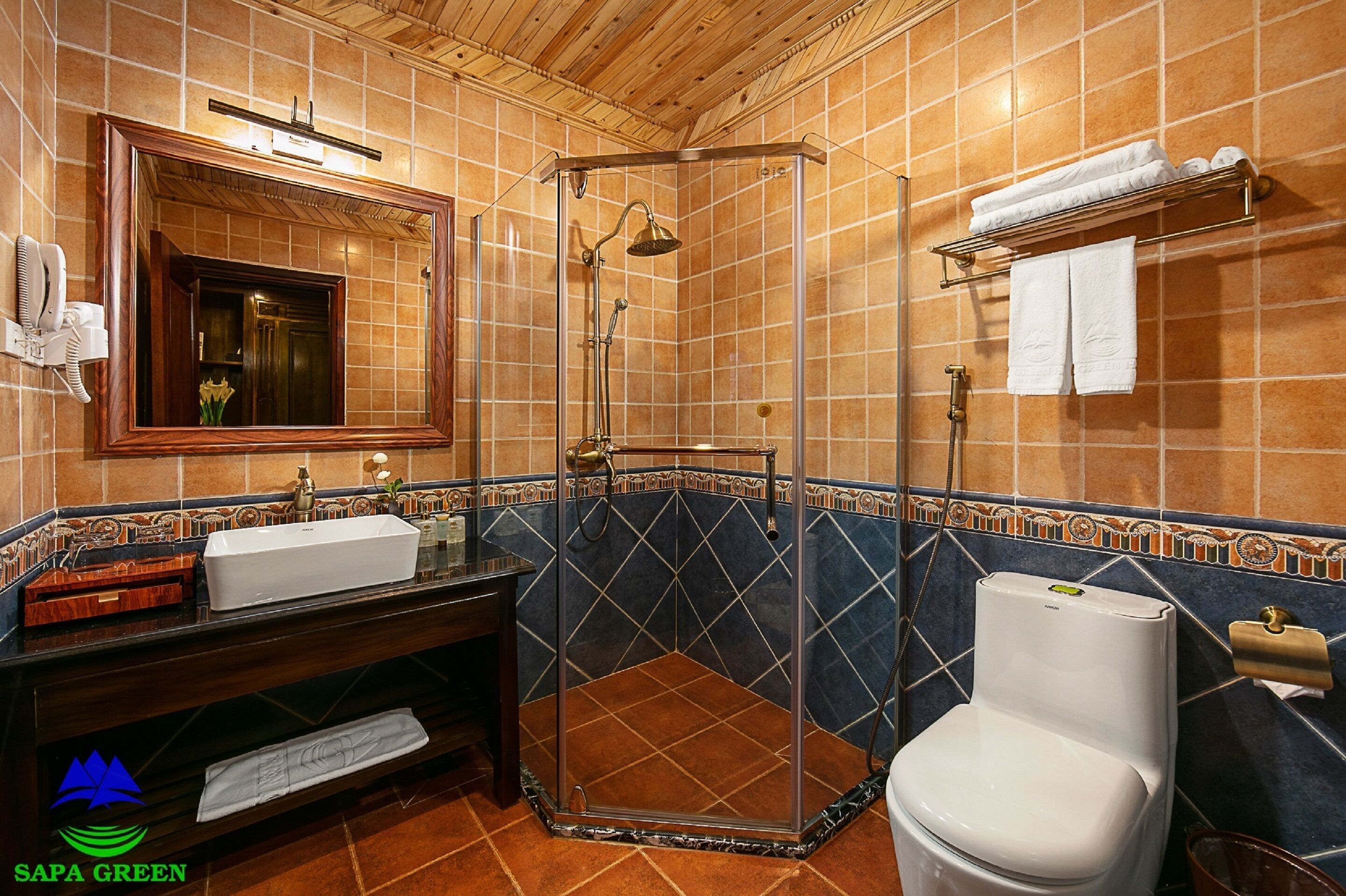 A bathroom with a shower, sink, toilet, and a towel rack.