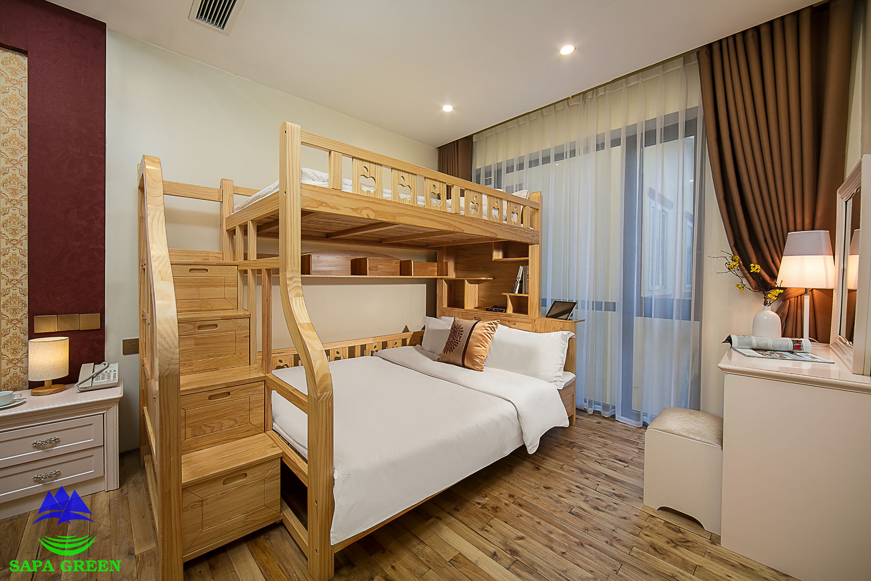 A bunk bed room with a desk and a lamp.