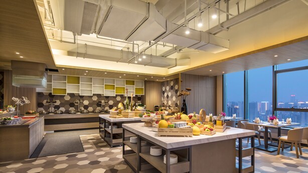 A modern kitchen with a central island, built-in shelves, and a large window offering a city view. - Citadines Gaoxin Xi'an (Xi'an)