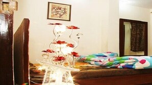 Un dormitorio con cama, espejo, televisor y una lámpara decorativa.