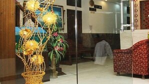 Entrada de hotel con un arreglo floral decorativo, una estatua y un letrero que dice 'HOTEL SAWERA INTERNATIONAL'.