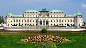 Ein großes, historisches Gebäude mit einer symmetrischen Fassade, mehreren Kuppeln und einem zentralen Eingang.