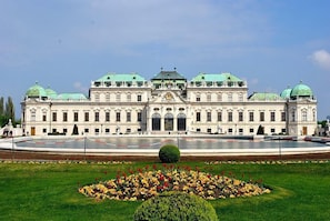 A large, historic building with a symmetrical facade, multiple domes, and a central entrance.