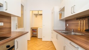 Eine moderne Küche mit Holzarbeitsplatten, einem eingebauten Backofen, einer Spüle und einem Geschirrständer.
