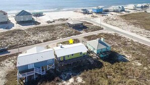 Una propiedad costera con varias construcciones, incluyendo una casa destacada con un símbolo de estrella, ubicada cerca de una playa y una carretera.