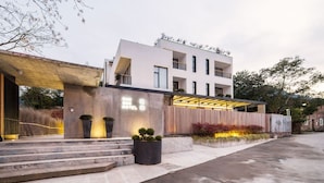 A modern hotel with a flat roof, multiple balconies, and a well-lit entrance. - Xun Sun Hotel (Hangzhou)