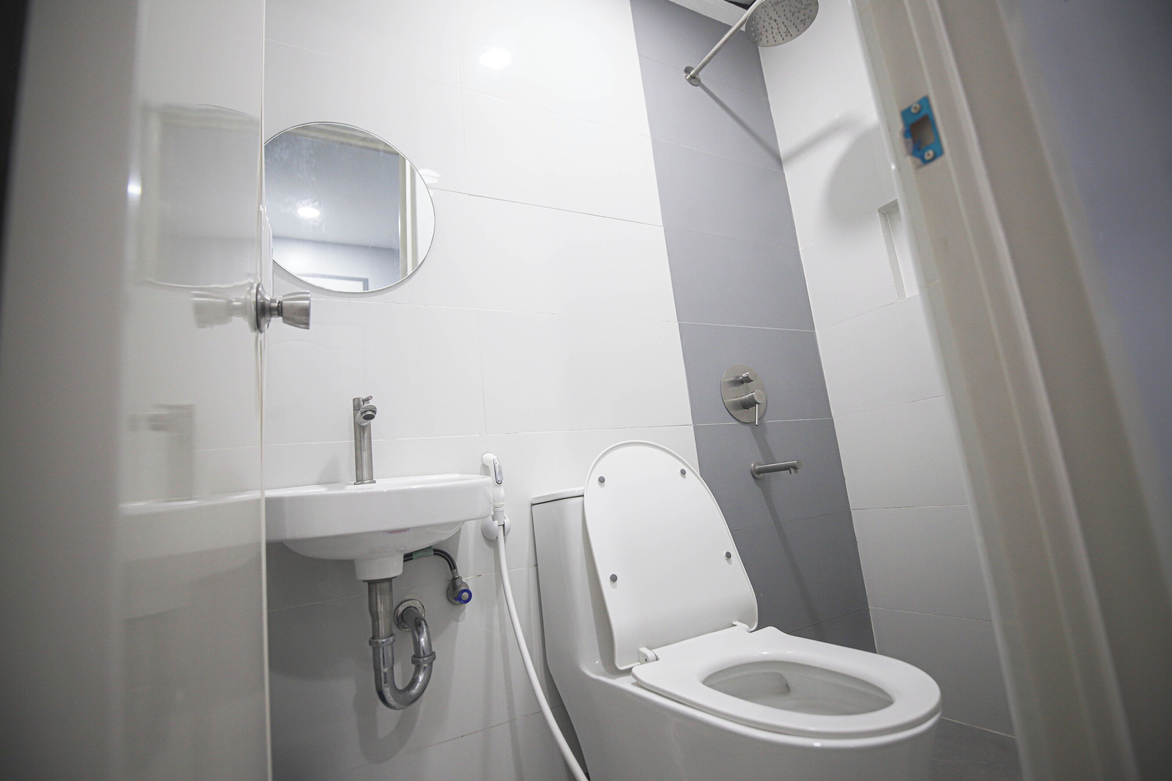 A modern bathroom with a toilet, sink, and shower.