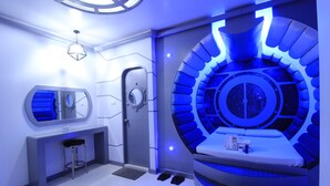 Un baño moderno con una zona de estar circular, un tocador con espejo y una puerta con ventanal circular.