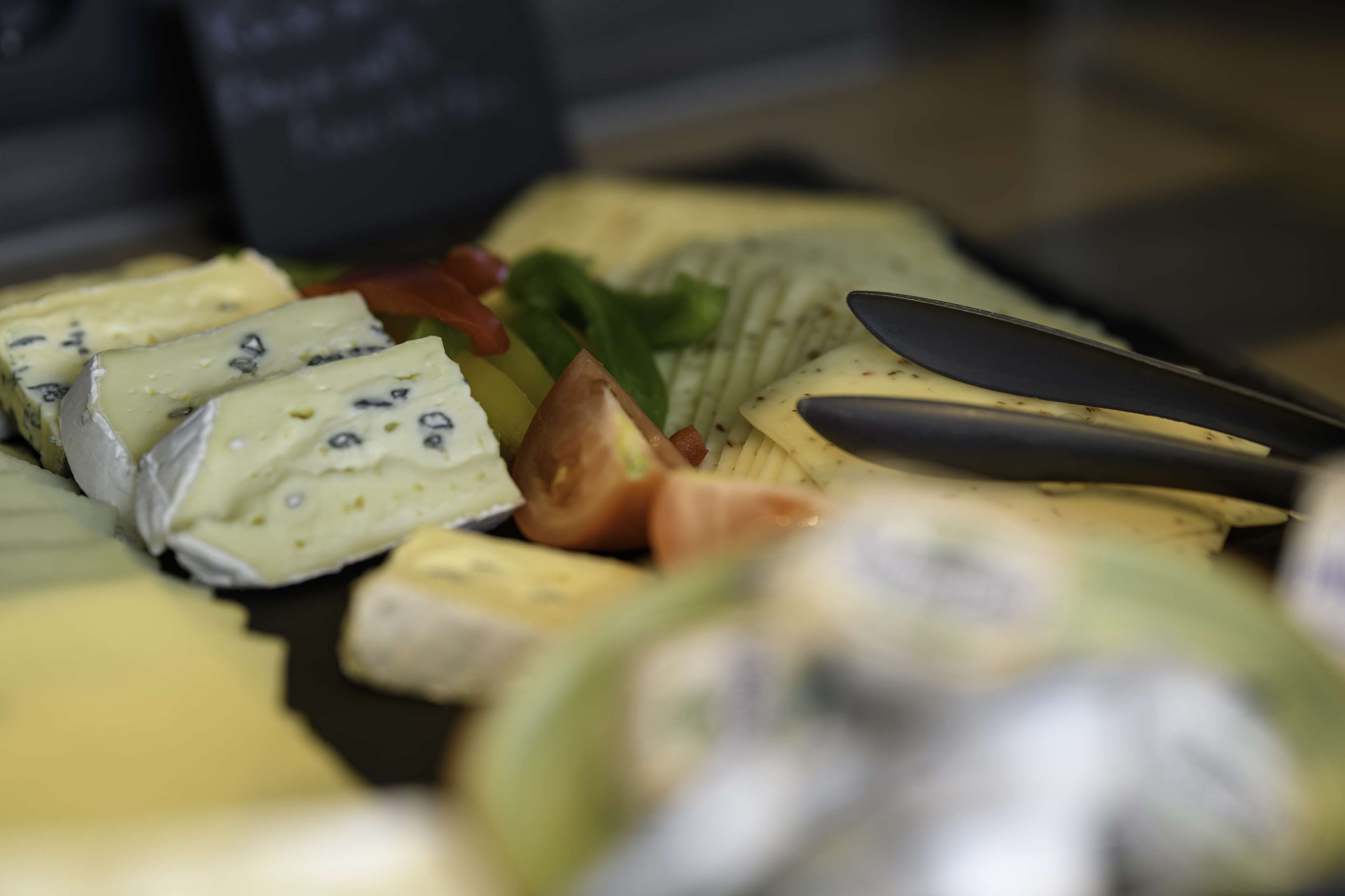 A variety of cheeses and fruits on a platter.