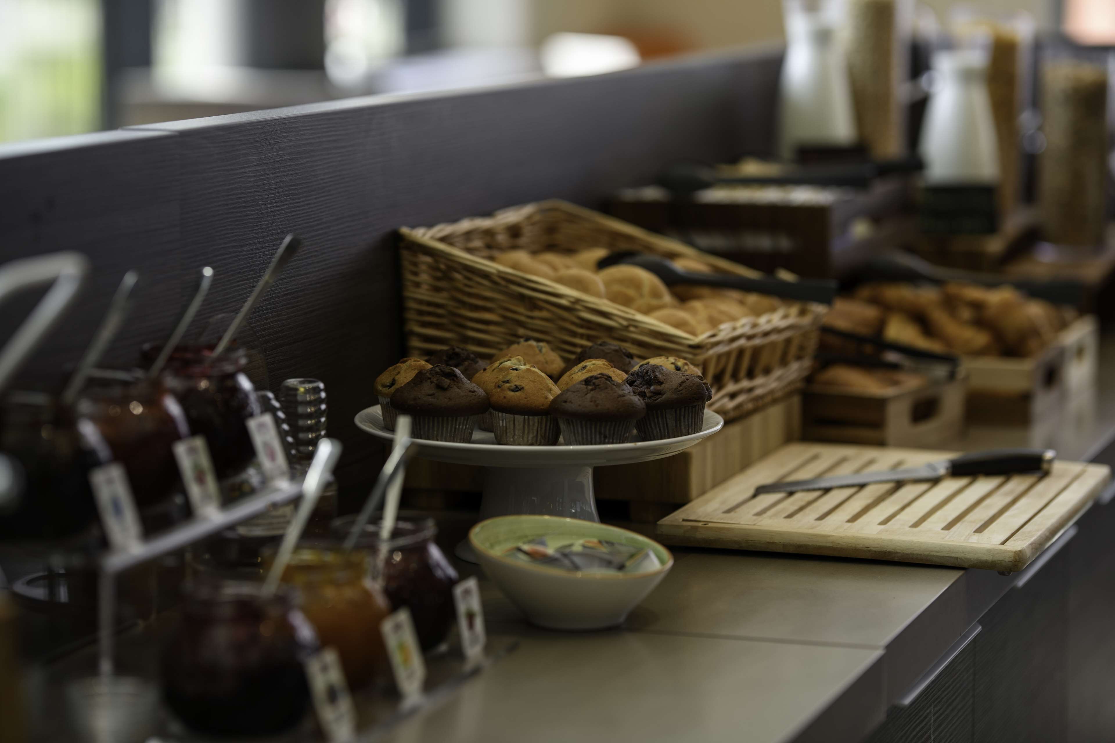 A bakery display with various baked goods and jars of spreads.