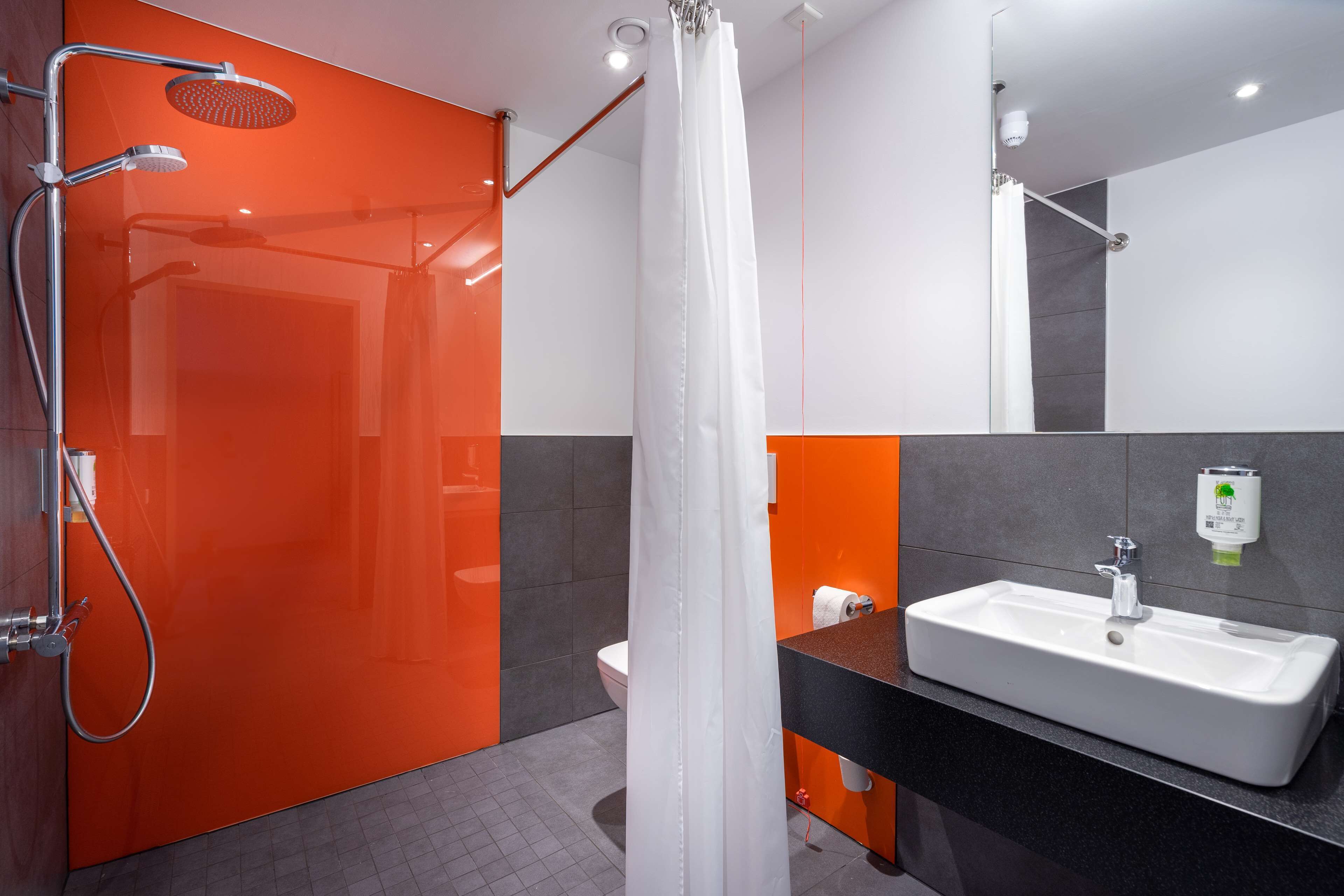 Une salle de bain moderne équipée d’une douche, de toilettes et d’un lavabo.