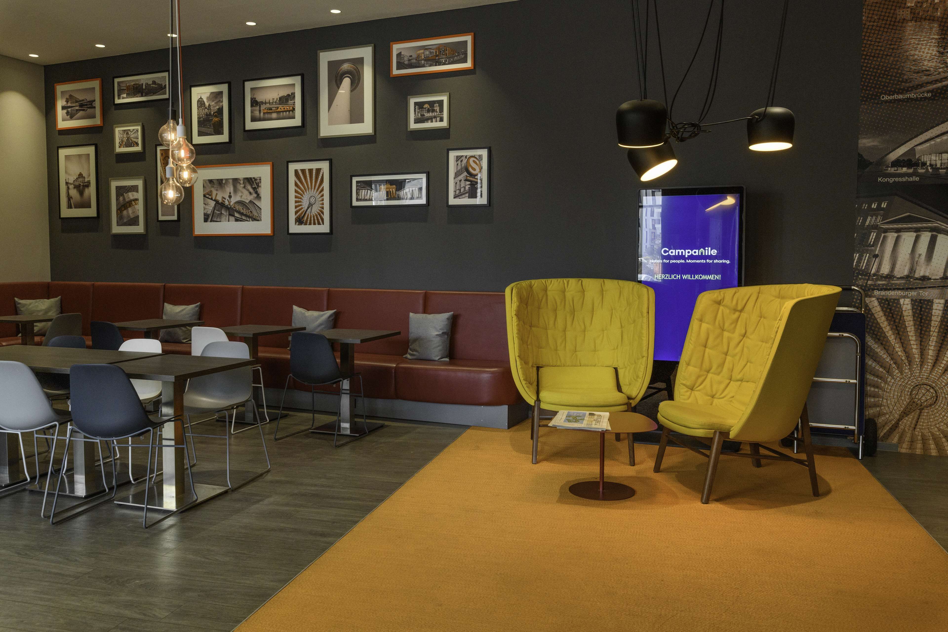 Un área de lounge moderna con asientos, mesas y cuadros en la pared.