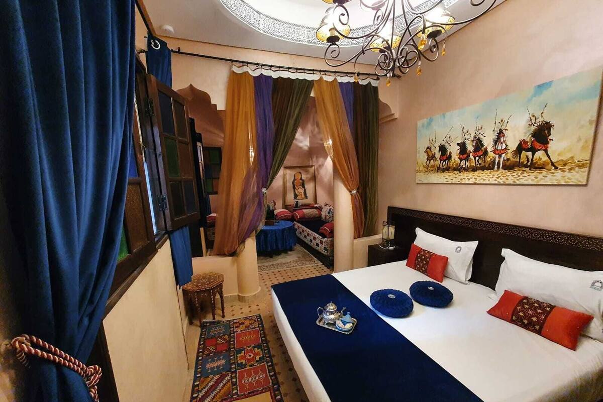 Una habitación de hotel con una cama grande, un tapete estampado y un cuadro en la pared.
