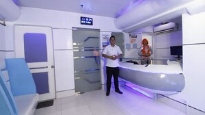 A reception area with a digital clock, a notice board, and a reception desk. - Astrotel Anonas (Quezon City)