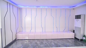 A modern interior with a bench, recessed lighting, and a wall-mounted air conditioning unit. - Astrotel Guadalupe (Makati)
