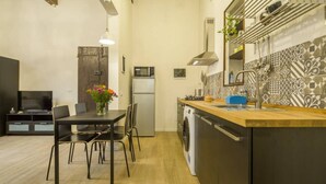 A compact kitchen with a microwave, oven, and washing machine.