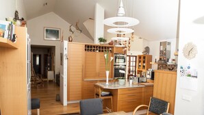 Una cocina moderna con armarios de madera, una isla central y un comedor con mesa y sillas.
