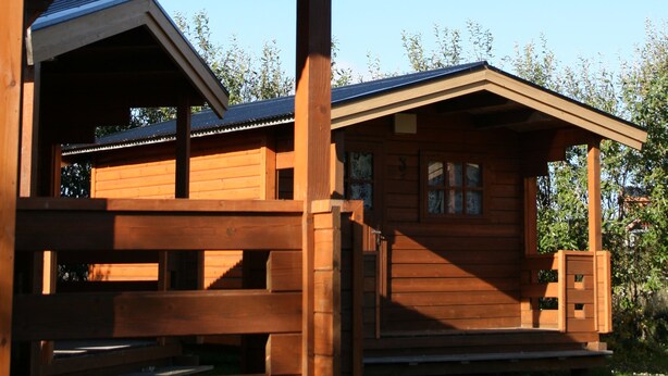 A wooden cabin with a porch and a covered area. - Huts in Víðidalur (Hvammstangi)