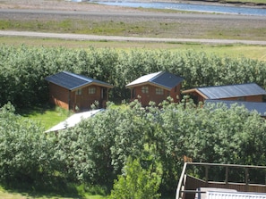 A cluster of cabins surrounded by dense foliage, with a gravel path leading to them. - Huts in Víðidalur (Hvammstangi)