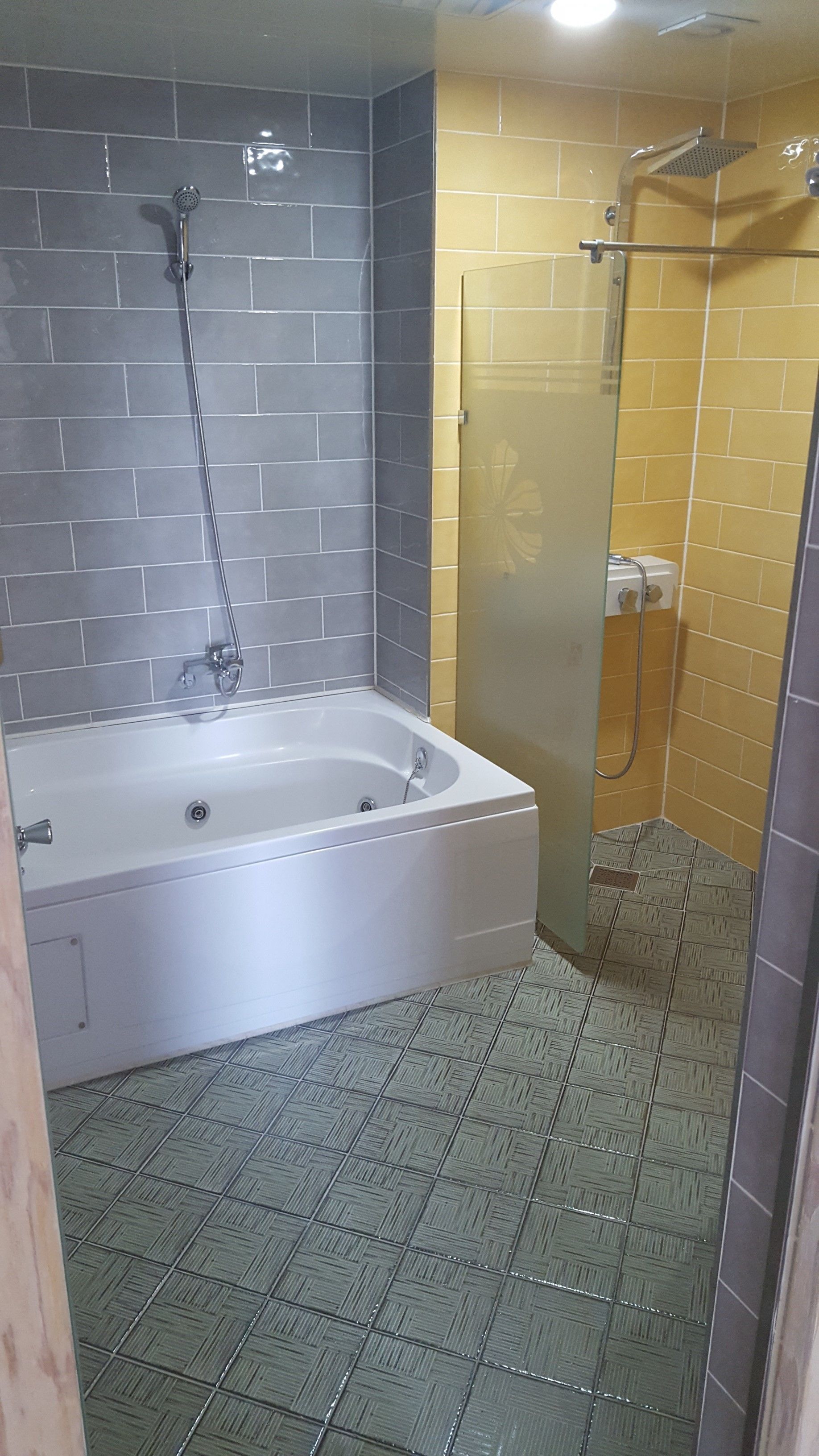 A bathroom with a bathtub, a shower, and a glass-enclosed shower stall.