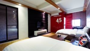 A modern hotel room with a large bed, a TV, a red accent wall, and a number '45' sign. - Snail Pets Homestay (Tainan)