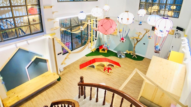 A children's playroom with a wooden play structure, a slide, and hanging decorations. - Snail Pets Homestay (Tainan)