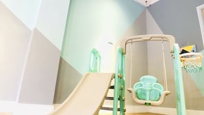 A children's play area with a slide and a small basketball hoop. - Snail Pets Homestay (Tainan)