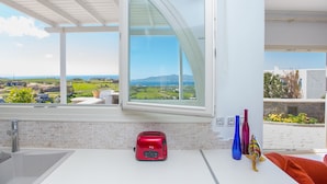 A modern kitchen with a large window, a toaster, and decorative vases. - villa victor 2 (Naxos)